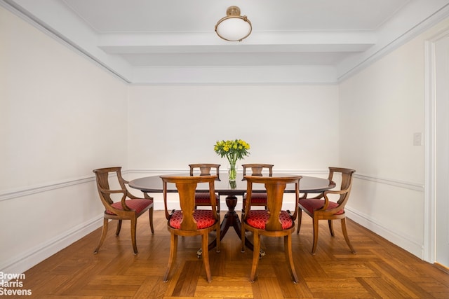 dining space with beam ceiling and baseboards