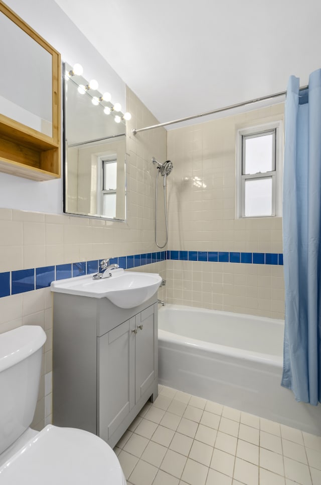 full bathroom featuring tile patterned flooring, toilet, vanity, tile walls, and shower / bath combination with curtain