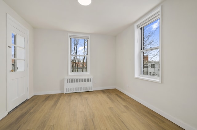 entryway with radiator, light wood finished floors, and baseboards