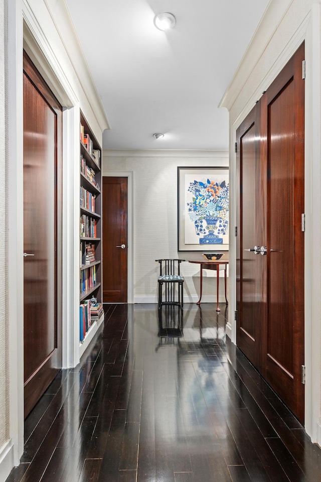 corridor with baseboards, ornamental molding, and dark wood finished floors