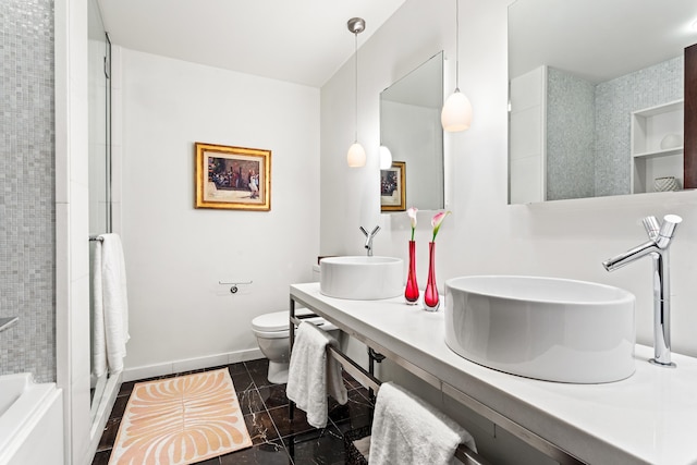 bathroom with double vanity, toilet, a sink, baseboards, and walk in shower