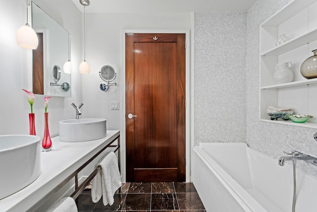 bathroom featuring a tub to relax in, double vanity, built in shelves, and a sink