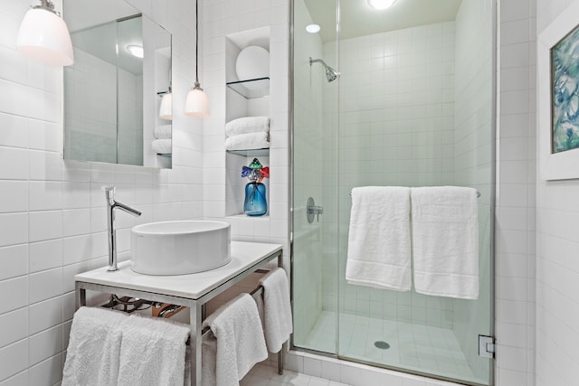 bathroom featuring a stall shower, vanity, tile walls, and decorative backsplash