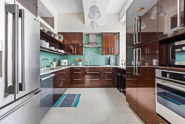 kitchen featuring a sink, light countertops, appliances with stainless steel finishes, wall chimney exhaust hood, and modern cabinets