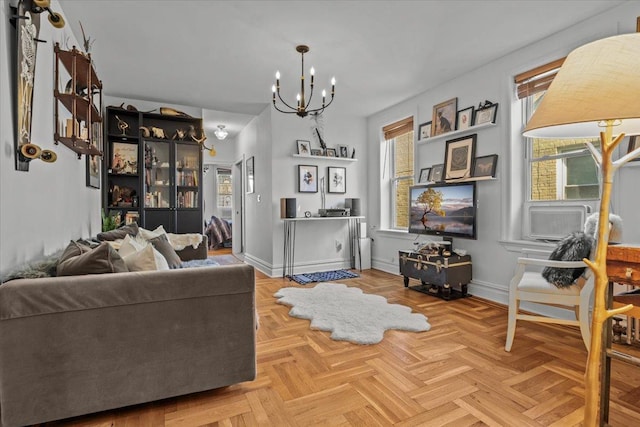 living room featuring a chandelier and baseboards