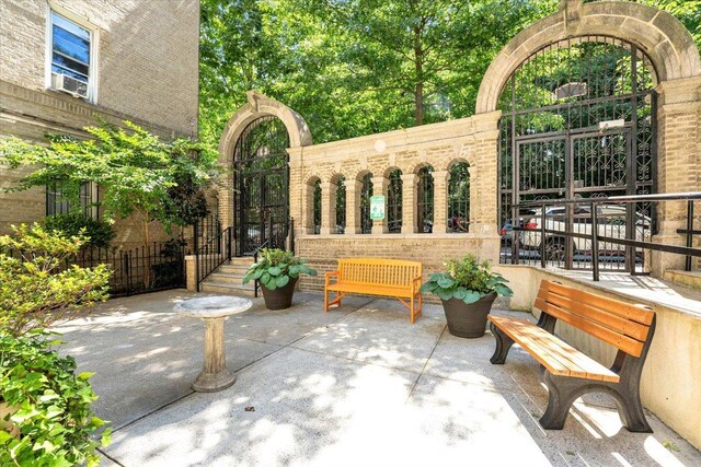 view of patio featuring cooling unit and a gate