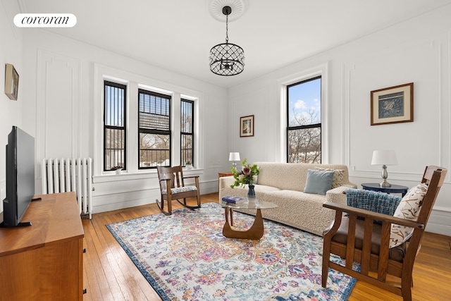 living area with light wood-type flooring, plenty of natural light, radiator, and visible vents