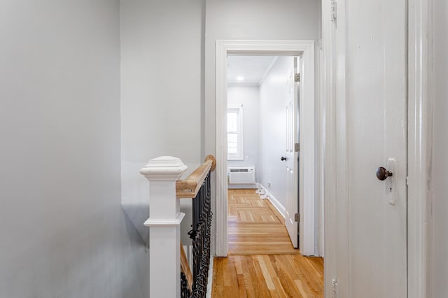 corridor featuring parquet floors, an upstairs landing, baseboards, and a wall mounted AC