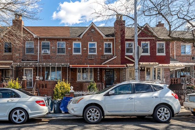 multi unit property featuring brick siding and a chimney