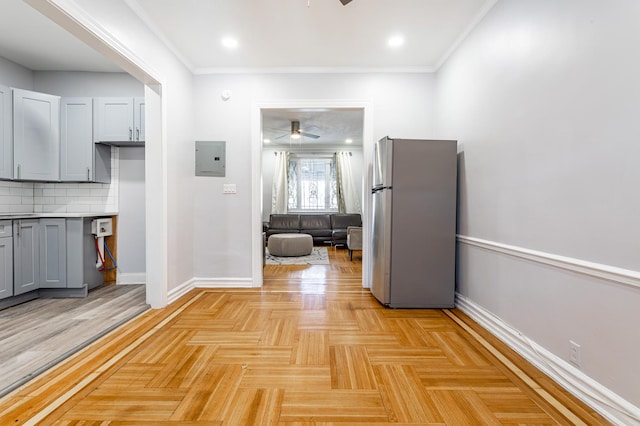 kitchen featuring baseboards, electric panel, freestanding refrigerator, gray cabinetry, and decorative backsplash