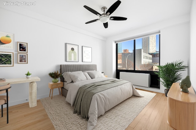 bedroom featuring ceiling fan, baseboards, and light wood-style floors