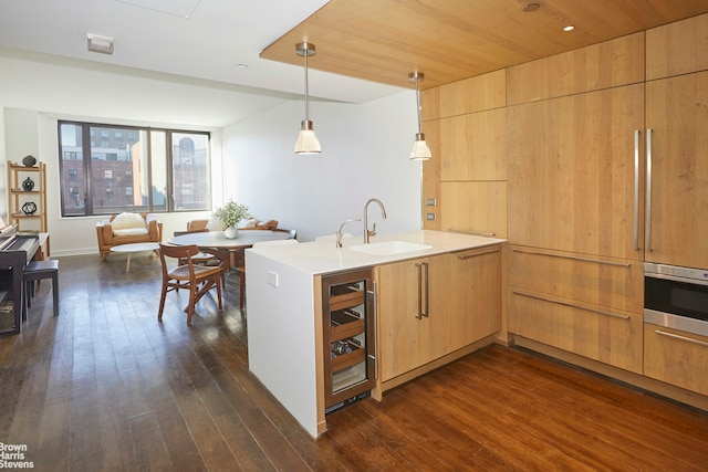 211 E 13th St Unit 6E, New York City, NY 10003 - kitchen featuring wine cooler, a sink, oven, a peninsula, and dark wood-style flooring
