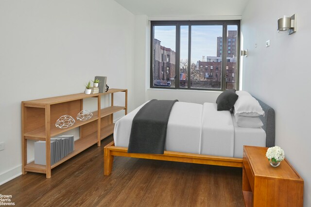 211 E 13th St Unit 6E, New York City, NY 10003 - bedroom featuring wood finished floors, a view of city, and baseboards