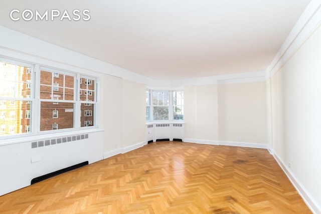 unfurnished room featuring baseboards and radiator