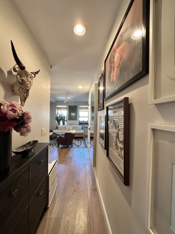 corridor featuring recessed lighting, wood finished floors, and baseboards