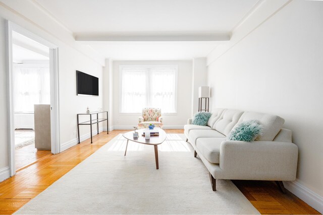 living room featuring beamed ceiling and baseboards