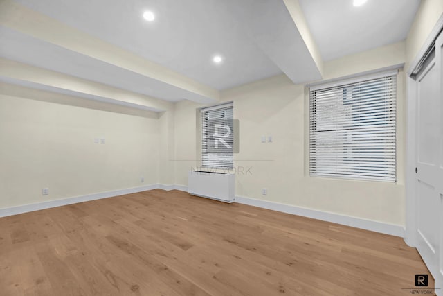 unfurnished room featuring recessed lighting, beamed ceiling, baseboards, and light wood-style flooring