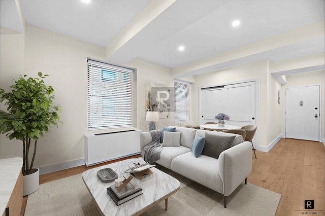 living room featuring recessed lighting, beamed ceiling, baseboards, and light wood finished floors