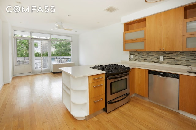 kitchen featuring open shelves, a peninsula, visible vents, and stainless steel appliances