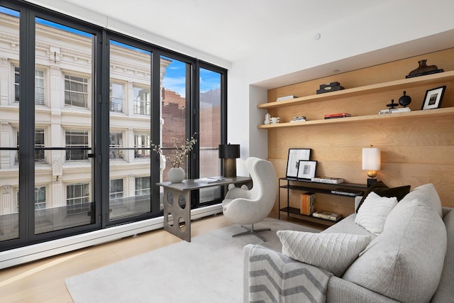 sitting room featuring a baseboard radiator, wood finished floors, and expansive windows