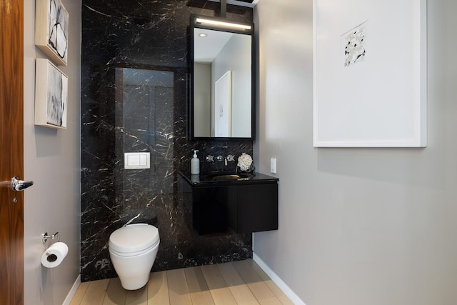 bathroom with toilet, wood finished floors, and vanity