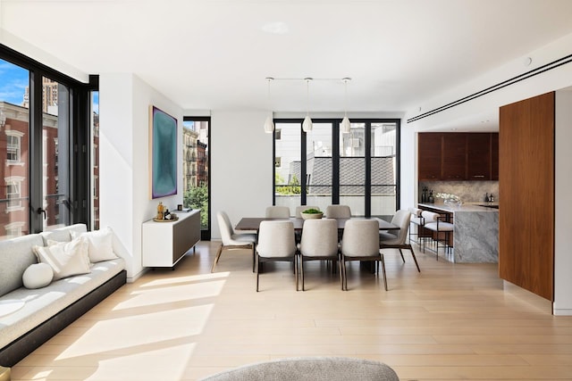 dining room featuring light wood-type flooring and expansive windows