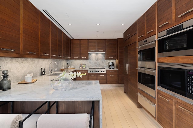 kitchen with tasteful backsplash, stainless steel appliances, modern cabinets, and a sink