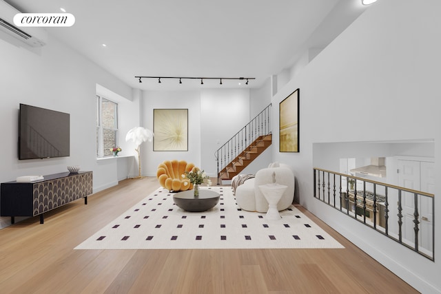 sitting room featuring wood finished floors, track lighting, an AC wall unit, recessed lighting, and baseboards