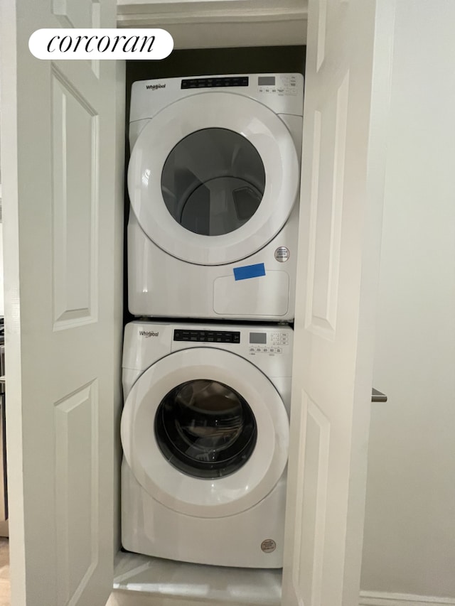 clothes washing area featuring stacked washer / dryer