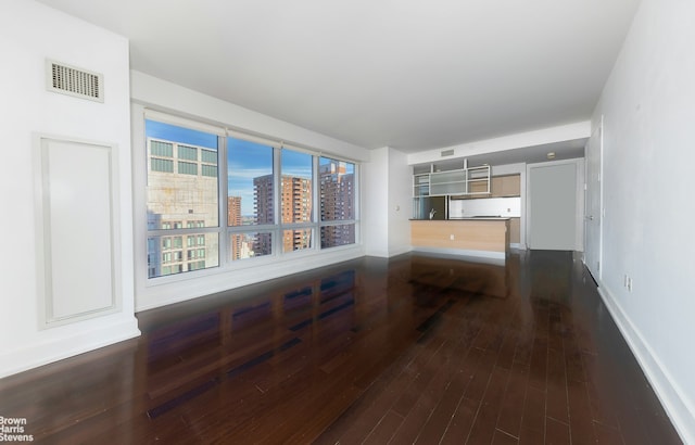 living room featuring dark wood-style floors, baseboards, a view of city, and visible vents