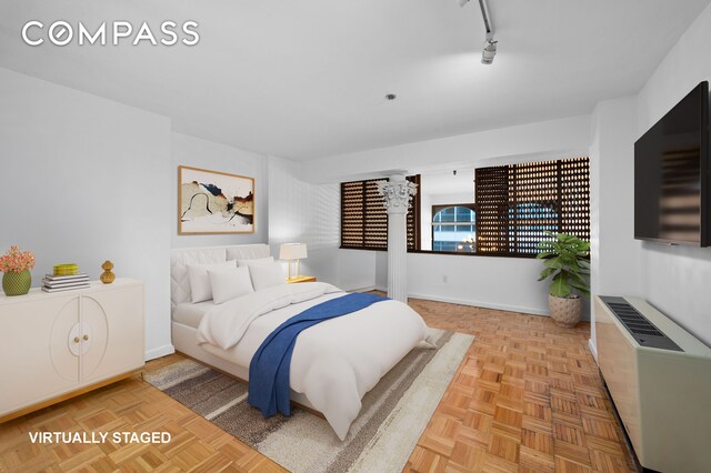 bedroom featuring rail lighting and baseboards