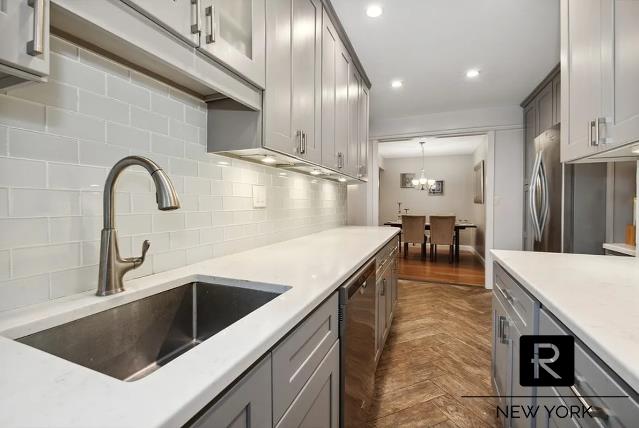 kitchen featuring recessed lighting, a sink, light countertops, stainless steel dishwasher, and tasteful backsplash