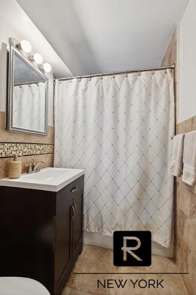 bathroom with tile patterned flooring, a shower with curtain, vanity, and toilet