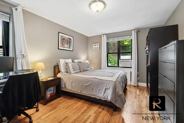 bedroom with light wood-type flooring and baseboards