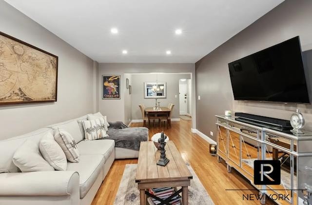 living area featuring light wood-type flooring, baseboards, and recessed lighting