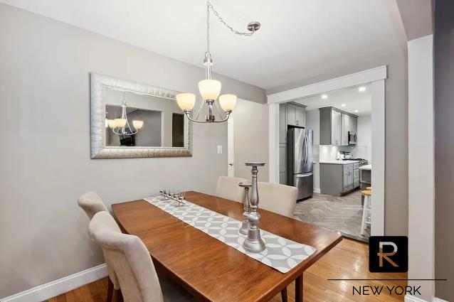 dining space with light wood finished floors, baseboards, and a notable chandelier