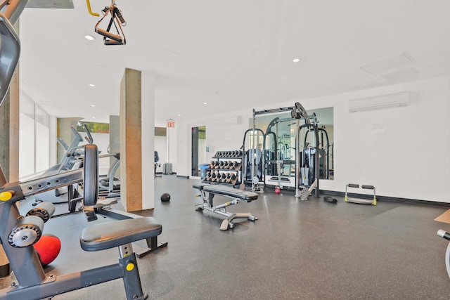 workout area with recessed lighting, a wall mounted air conditioner, and baseboards