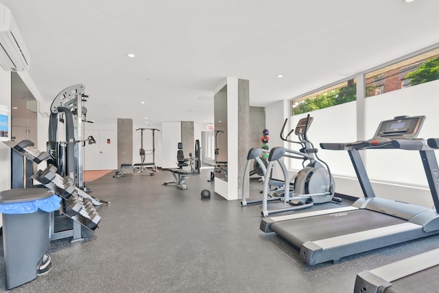 exercise room featuring recessed lighting and a wall mounted air conditioner