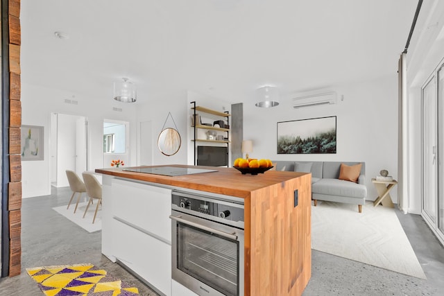 kitchen featuring oven, black electric stovetop, butcher block countertops, white cabinetry, and a wall unit AC