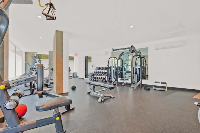 gym featuring recessed lighting, a wall mounted air conditioner, and a wealth of natural light