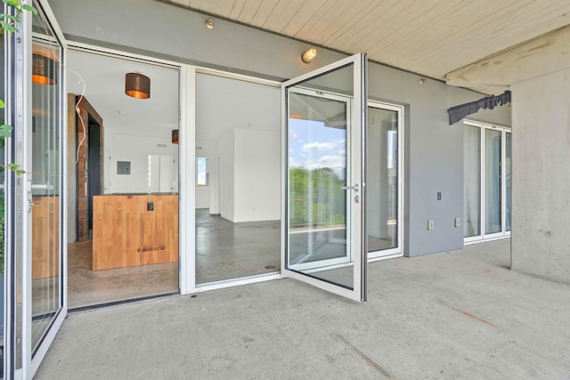 view of exterior entry with a patio and stucco siding