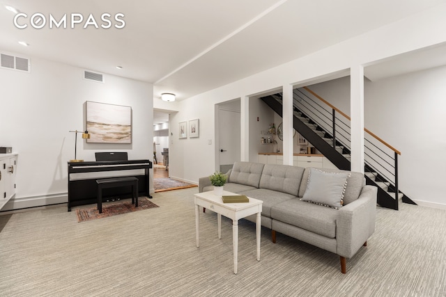 living area featuring stairway, carpet flooring, baseboards, and visible vents