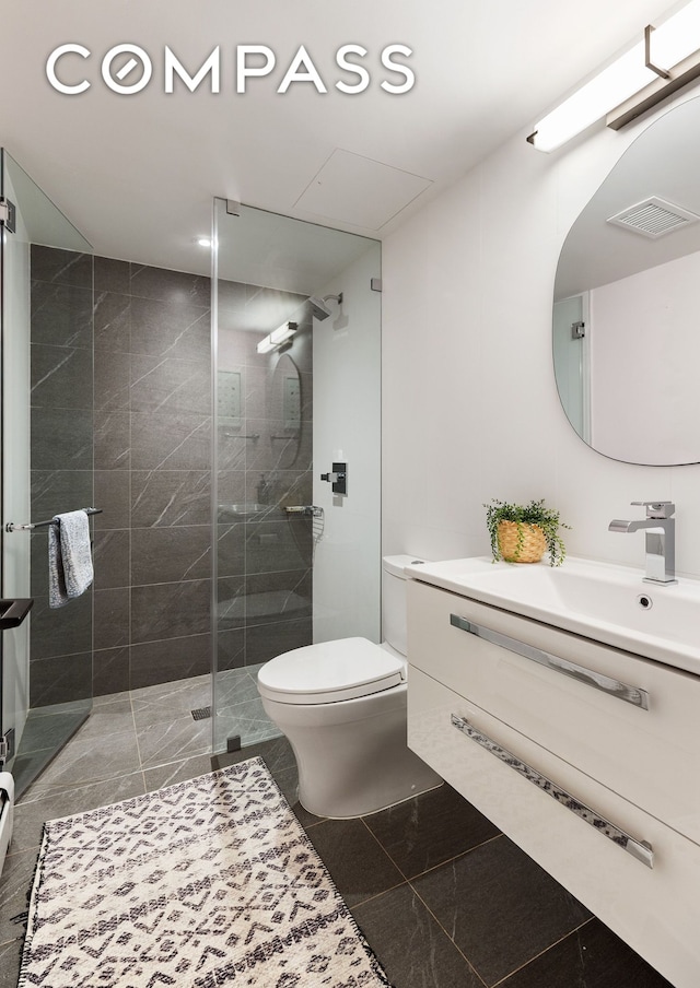 bathroom featuring visible vents, toilet, a stall shower, marble finish floor, and vanity