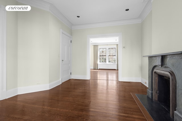 unfurnished living room featuring visible vents, baseboards, wood finished floors, and ornamental molding