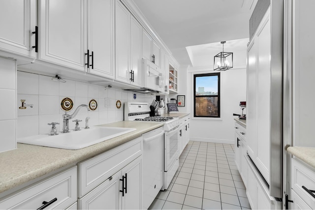 345 E 52nd St Unit 12A, New York City, NY 10022 - kitchen with a sink, light tile patterned floors, white appliances, white cabinetry, and light countertops
