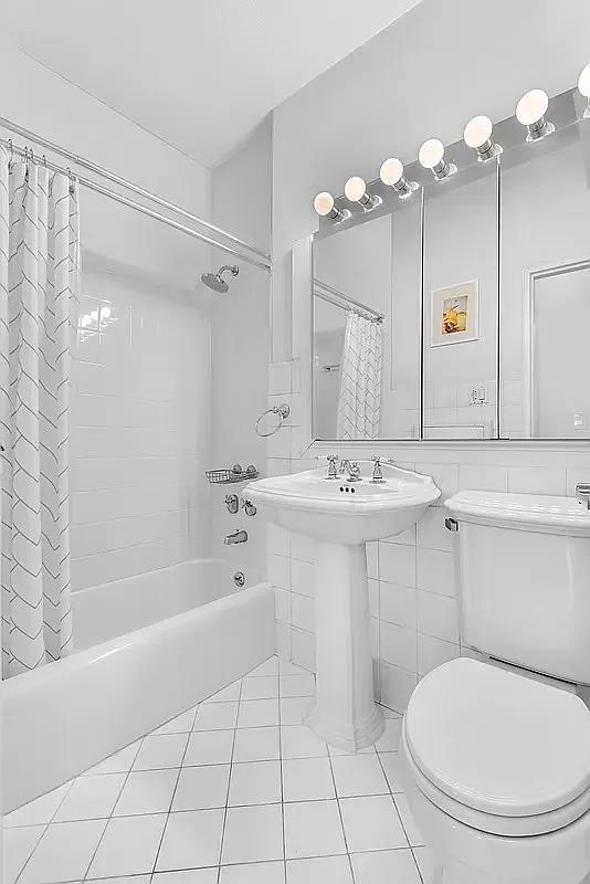 full bathroom with tile patterned flooring, toilet, tile walls, and shower / tub combo with curtain