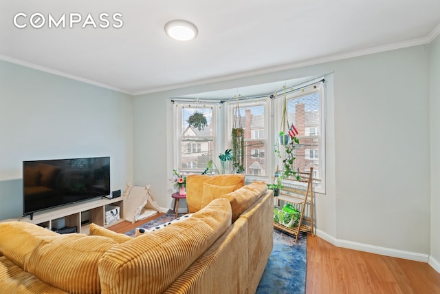 living room with ornamental molding, a healthy amount of sunlight, baseboards, and wood finished floors