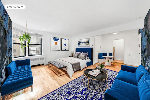 bedroom featuring radiator heating unit, wood finished floors, and visible vents