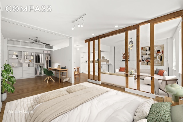 bedroom featuring french doors, rail lighting, and wood finished floors