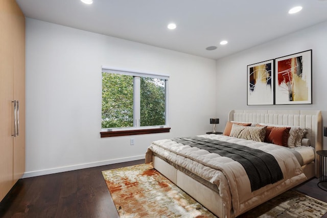 bedroom with recessed lighting, wood finished floors, and baseboards